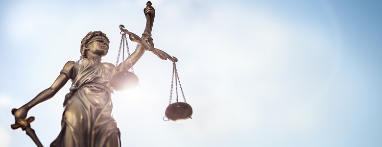 Legal law concept statue of Lady Justice with scales of justice sky background